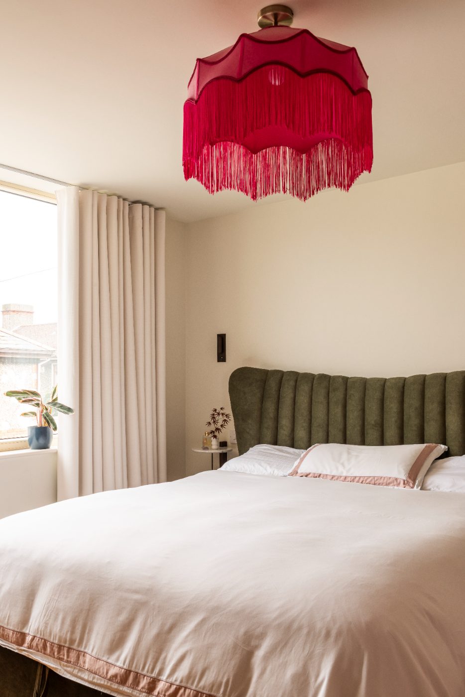 Bedroom with a pink fringed pendant lamp